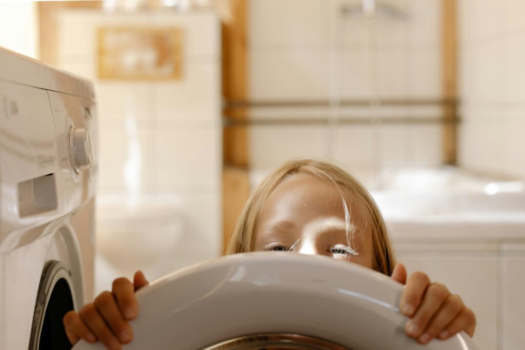 Une petite fille avec un lave linge